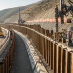 Eğimli arazide uygulanan Berlin Duvarı Sistemi; Foretek makinesiyle çakılan çelik kazıklar, ahşap paneller, yol kenarı kazı ve zemin ankrajı uygulaması